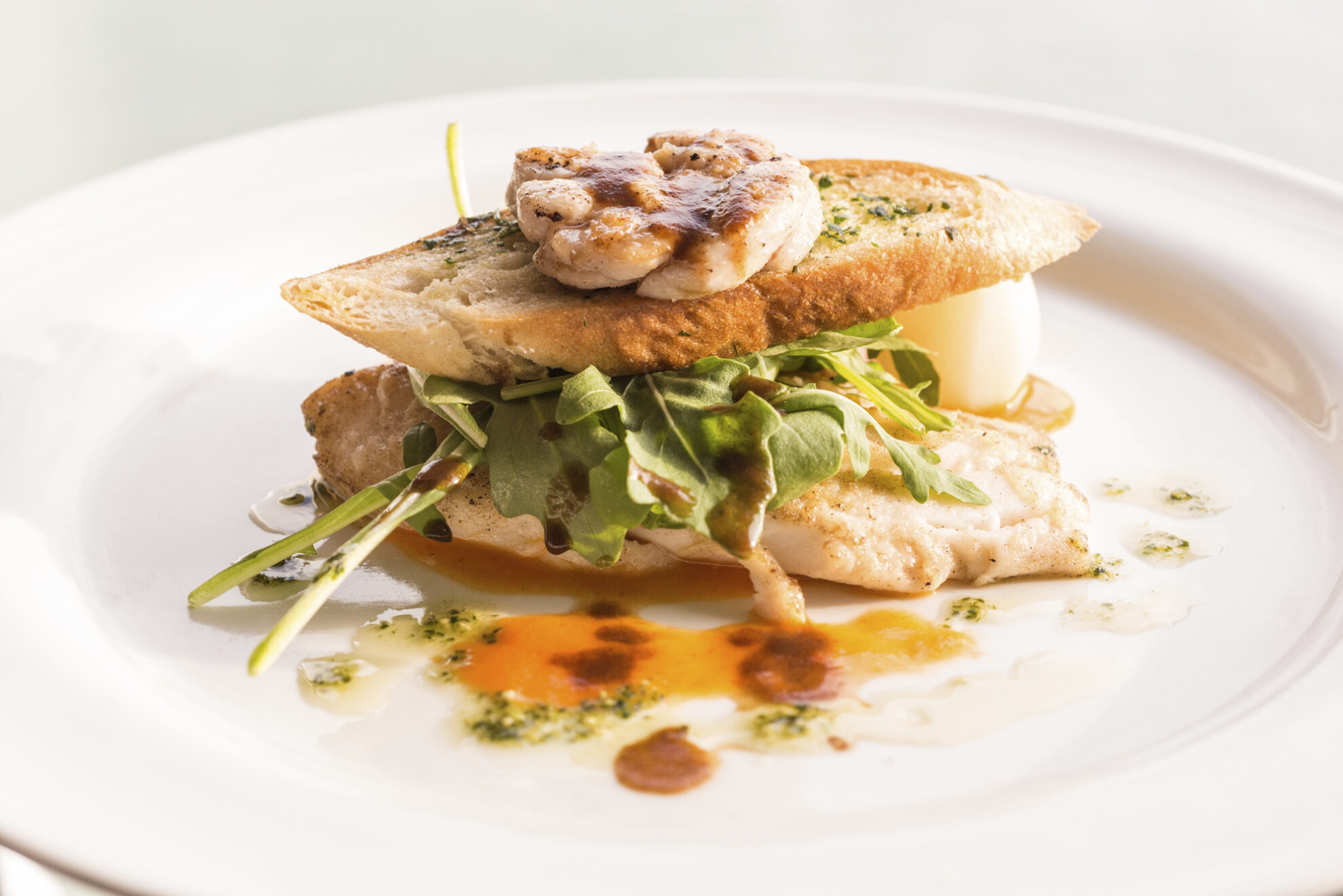 schmackhaft zubereitetes Hähnchenbrustfilet zwischen zwei Scheiben frischen Kreuterbaguette