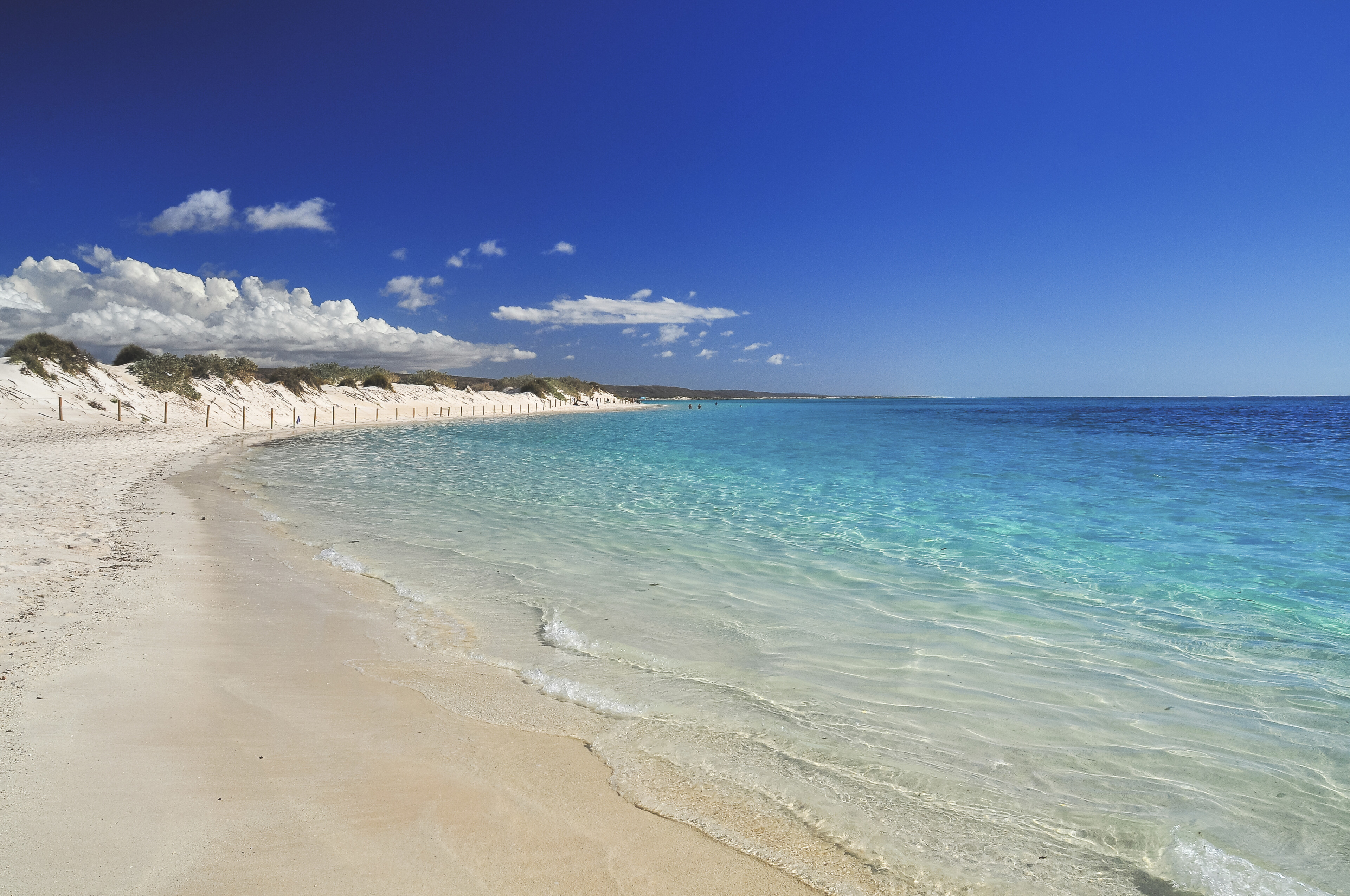 Weißer Sandstrand mit türkisblauem Wasser