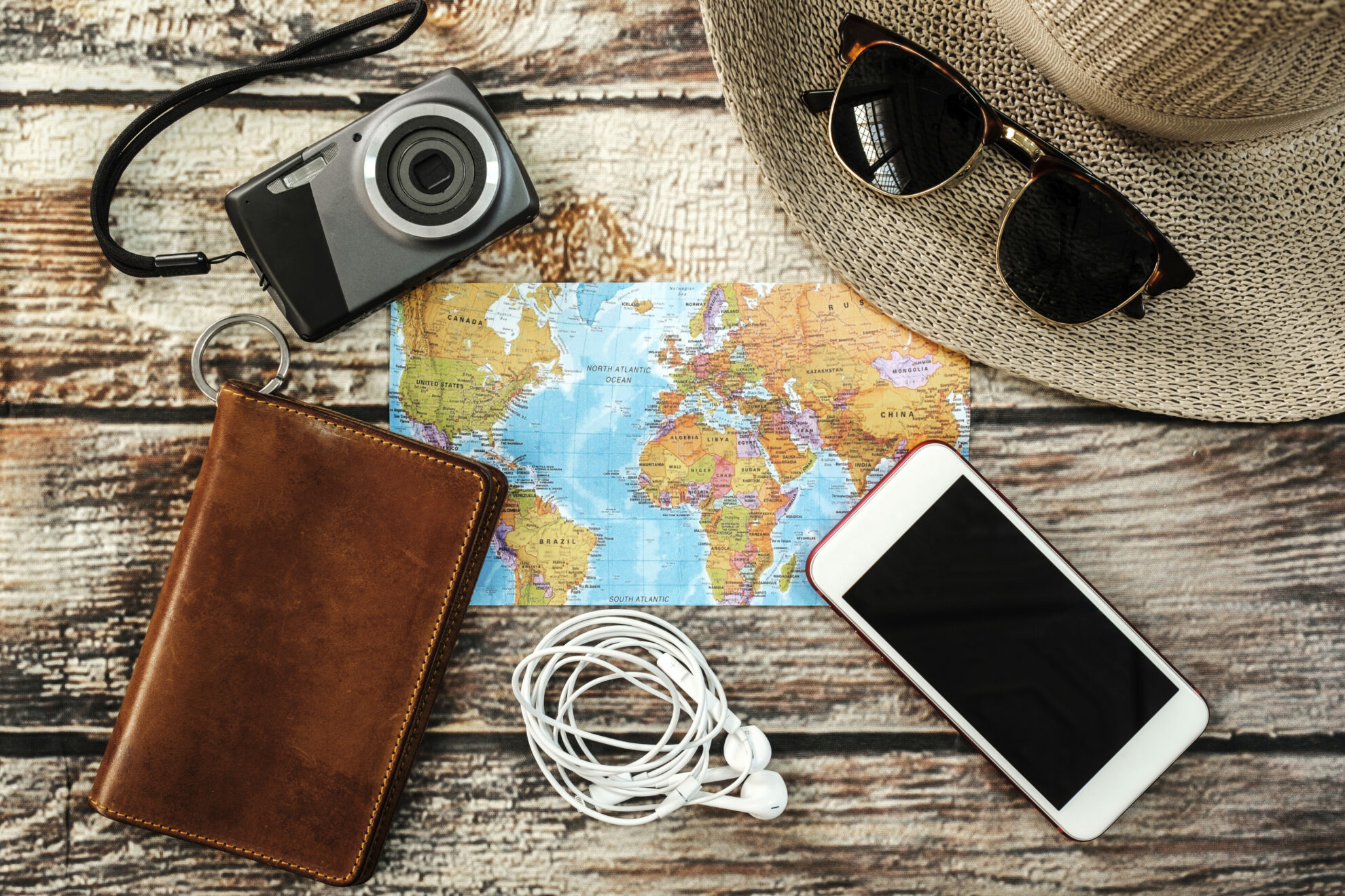 shutterstock 720944506 landkarte reiseutensilien kamera sonnenbrille smartphone geldbeutel sonnenhut tischjpg 3672612